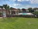 Community pool and clubhouse with lush landscaping on a sunny day at 3026 Bella Vista Dr, Davenport, FL 33897