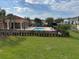 View of community pool and clubhouse from the backyard, surrounded by lush grass at 3026 Bella Vista Dr, Davenport, FL 33897