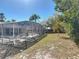 The screen-enclosed pool sits in the backyard surrounded by tropical trees and landscaping at 3252 Noah St, Deltona, FL 32738
