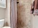 Walk-in shower that features earth-toned tile, a mosaic tile accent, and a shower curtain at 3252 Noah St, Deltona, FL 32738