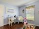 Cozy sitting area with hardwood floors, white wicker furniture, and natural light from the window at 3252 Noah St, Deltona, FL 32738