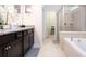 Elegant bathroom featuring a double vanity with granite countertops, soaking tub, and separate glass shower at 3428 Lilac Way, Davenport, FL 33897