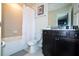 Bathroom with a shower and tub combination, dark wood vanity, and tile backsplash at 3428 Lilac Way, Davenport, FL 33897