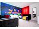 Bright bedroom featuring two twin beds, a large mural, and vibrant red curtains at 3428 Lilac Way, Davenport, FL 33897