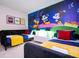 Bright bedroom with twin beds, red accents, and fun cartoon-themed wallpaper at 3428 Lilac Way, Davenport, FL 33897