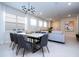 Modern dining room features a stylish table and seating adjacent to the open concept living area at 3428 Lilac Way, Davenport, FL 33897