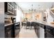 Modern kitchen featuring stainless steel appliances, dark cabinetry and an open floor plan at 3428 Lilac Way, Davenport, FL 33897
