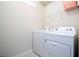 Well-lit laundry room features a Whirlpool washer and dryer, and a storage shelf at 3428 Lilac Way, Davenport, FL 33897