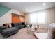Bright living room featuring stylish gray sectional sofa, decorative wall accents, and sheer window curtains at 3428 Lilac Way, Davenport, FL 33897