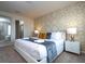 Comfortable main bedroom with a king bed, geometric accent wall, and stylish furnishings at 3428 Lilac Way, Davenport, FL 33897