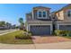 Attractive townhome featuring a brick driveway, two-car garage, and tidy landscaping at 3593 Brighton Park Cir, Belle Isle, FL 32812
