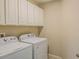 Bright laundry room featuring a washer and dryer and overhead storage cabinets at 3593 Brighton Park Cir, Belle Isle, FL 32812