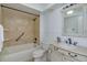 Bathroom featuring tiled shower-tub combo, vanity with a cream-colored countertop, and a decorative mirror at 409 Oak Haven Dr # 409, Altamonte Springs, FL 32701