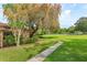 Home exterior with large yard, flowering tree, and community tennis courts at 409 Oak Haven Dr # 409, Altamonte Springs, FL 32701