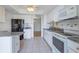 Well-lit kitchen with white cabinetry, stainless steel appliances, and a tile backsplash at 409 Oak Haven Dr # 409, Altamonte Springs, FL 32701
