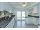 Charming kitchen boasts white cabinetry, granite countertops, stainless steel sink, and outdoor access at 409 Oak Haven Dr # 409, Altamonte Springs, FL 32701