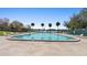 View of a pristine community pool, lined with palm trees and lounge chairs at 4268 Lake Underhill Rd # 4, Orlando, FL 32803