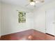Cozy bedroom featuring hardwood floors, a window, and a white door at 46 Smyrna Dr, Debary, FL 32713