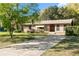 Well-maintained brick house with a lush front yard, a long driveway, and mature trees in a serene setting at 46 Smyrna Dr, Debary, FL 32713