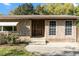 Charming brick home with mature trees, a quaint entrance, and ample natural light streaming through the windows at 46 Smyrna Dr, Debary, FL 32713