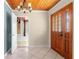 Inviting foyer with wood ceiling, tile floor and a beautiful wooden front door at 46 Smyrna Dr, Debary, FL 32713