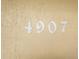 Close-up of house numbers '4907' on a textured beige stucco wall at 4907 Lindsay Ct, Orlando, FL 32821