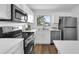 Modern kitchen with stainless steel appliances, white cabinets, and quartz countertops at 4907 Lindsay Ct, Orlando, FL 32821