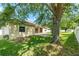 Well-maintained backyard featuring lush lawn, mature tree, and a cozy patio area perfect for outdoor relaxation at 5055 Coveview Dr, St Cloud, FL 34771