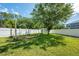 Fenced backyard featuring green lawn, mature trees, and a storage shed for convenience and extra storage at 5055 Coveview Dr, St Cloud, FL 34771