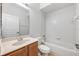 Bright bathroom featuring a tub/shower combo, toilet, vanity and neutral tile flooring at 5055 Coveview Dr, St Cloud, FL 34771