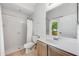 Well-lit bathroom featuring a walk-in shower and vanity, with natural light from the window at 5055 Coveview Dr, St Cloud, FL 34771