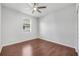 Neutral bedroom with hardwood floors, ceiling fan, and natural light from the window at 5055 Coveview Dr, St Cloud, FL 34771