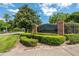 Elegant community entrance sign surrounded by manicured landscaping and mature trees at 5055 Coveview Dr, St Cloud, FL 34771