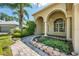 Charming home featuring arched entryway, lush landscaping, and a welcoming walkway leading to the front door at 5055 Coveview Dr, St Cloud, FL 34771