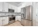 Bright kitchen featuring stainless steel appliances, white cabinetry and neutral backsplash at 5055 Coveview Dr, St Cloud, FL 34771