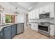 Well-lit kitchen featuring stainless steel appliances, blue island, and tiled backsplash at 5055 Coveview Dr, St Cloud, FL 34771