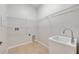 Bright laundry room with utility sink, tile floors, and shelving for storage at 5055 Coveview Dr, St Cloud, FL 34771