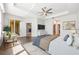 Large main bedroom featuring tray ceiling, ceiling fan and sitting area with modern decor at 5055 Coveview Dr, St Cloud, FL 34771