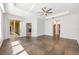 Spacious main bedroom featuring tray ceilings, ceiling fan, large windows, and an arched doorway at 5055 Coveview Dr, St Cloud, FL 34771