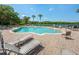 Community pool with lounge chairs and lake views, perfect for relaxing and enjoying the outdoors at 5055 Coveview Dr, St Cloud, FL 34771