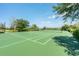 Well-maintained tennis court with green surface, surrounded by trees and a fence, perfect for a match at 5055 Coveview Dr, St Cloud, FL 34771