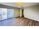 Bright bedroom features hardwood flooring and large sliding glass doors with vertical blinds at 5268 Middle Ct # 111, Orlando, FL 32811