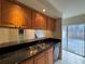 Kitchen featuring wood cabinets, black countertops, and stainless steel sink at 5268 Middle Ct # 111, Orlando, FL 32811