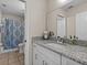 Updated bathroom with a granite-topped vanity, a shower/tub combo, and tile flooring at 5325 Cypress Reserve Pl, Winter Park, FL 32792