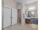 Spacious bathroom featuring dual doors, gray vanity with seating, and a toilet room at 5325 Cypress Reserve Pl, Winter Park, FL 32792