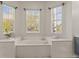 Elegant bathroom featuring a soaking tub surrounded by three large windows at 5325 Cypress Reserve Pl, Winter Park, FL 32792