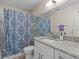 Stylish bathroom featuring a granite-topped vanity, decorative shower curtain, and sleek fixtures at 5325 Cypress Reserve Pl, Winter Park, FL 32792
