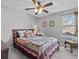 Cozy bedroom with a wood frame bed, colorful quilt, and a ceiling fan at 5325 Cypress Reserve Pl, Winter Park, FL 32792