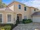 Charming two-story home featuring neutral stucco, lush landscaping, and brick paved driveway at 5325 Cypress Reserve Pl, Winter Park, FL 32792