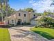 Charming two-story home featuring a brick paver driveway, lush landscaping, and a side-entry garage at 5325 Cypress Reserve Pl, Winter Park, FL 32792